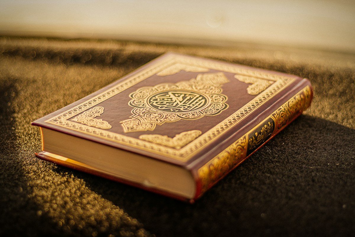 A Quran with an ornate gold cover in warm natural light